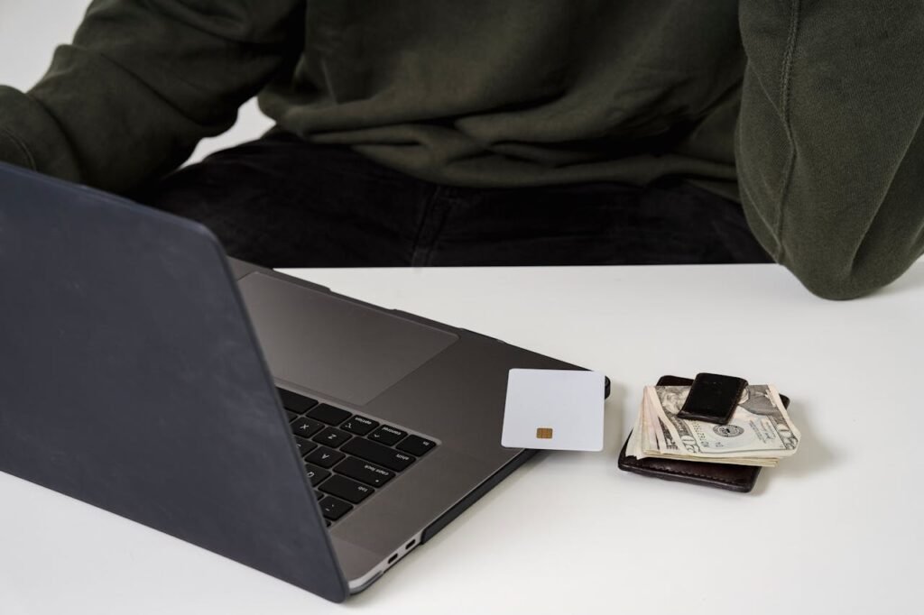 A man using a laptop and credit card for online shopping, highlighting e-commerce convenience.