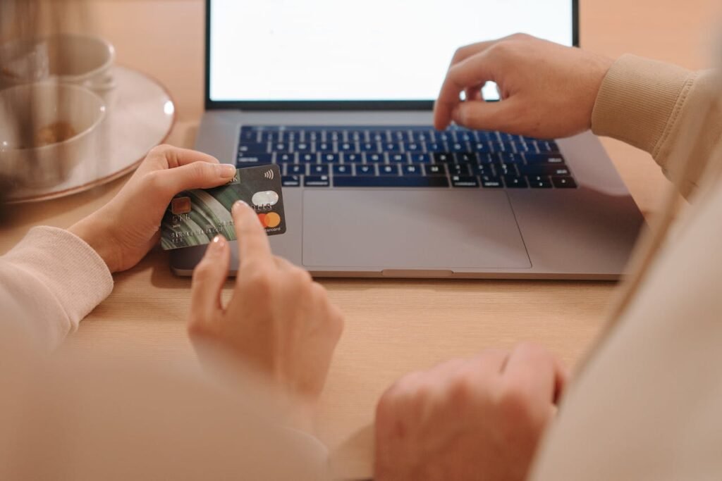 Two adults making an online purchase with a laptop and credit card.
